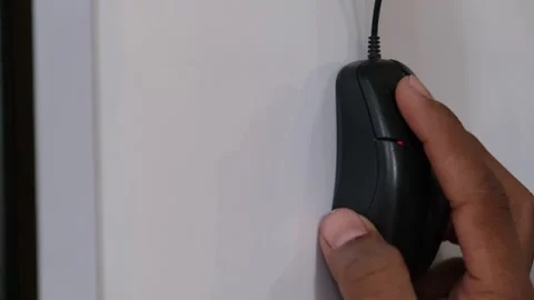 Side View of a Hand Operating a Black Wired Computer Mouse on a White Desktop Видео 330572885