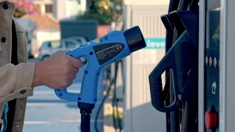 Side View of Hand Placing Blue Electric Vehicle Charging Nozzle on Terminal Видео 341548392