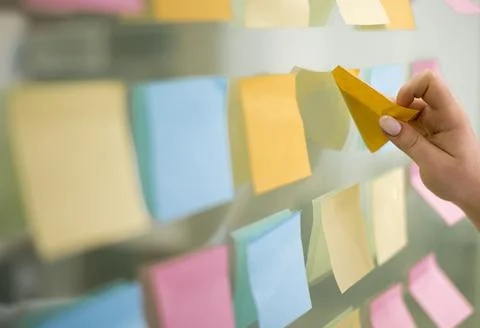 Side view hand putting sticky notes window . High quality and resolution Stock Photos