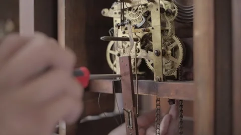 Side view hand screw driver working on antique clock Stock Footage 341636855