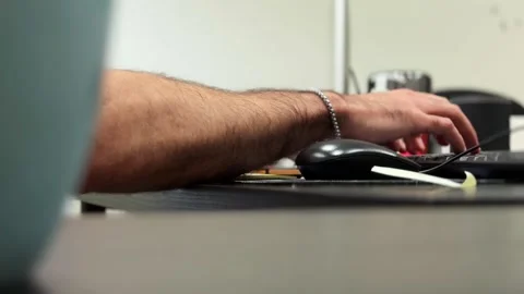 Side view of hand using computer mouse at desk in modern office workspace Stock Footage 333423274