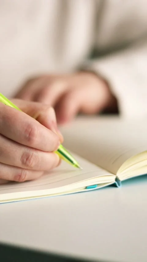 Side view of hand writing notes with pen in plain notebook. Minimalist Stock Footage 307751878