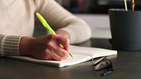 Side view of hand writing notes with pen in plain notebook. Minimalist Stock Footage 310267353