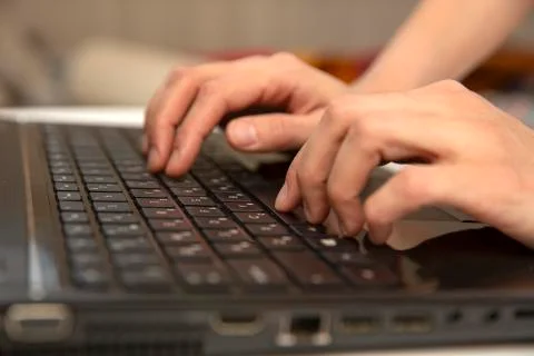 Side view of the hands of a beautiful young hipster woman busy on her laptop Stock Photos