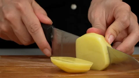 Side View of Hands Slicing Raw Potato on Board Stock Footage 343593492