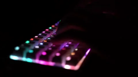 Side view of hands typing on illuminated RGB keyboard in the dark Stock Footage 150978794