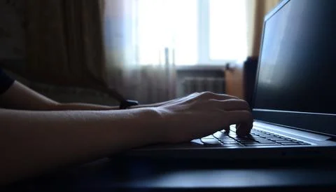 Side view hands typing on a laptop, a person writing an email, working from.. Stock Photos