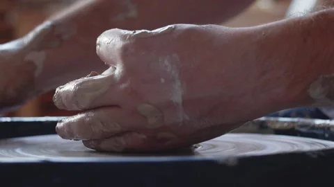 Side view of hands work on pottery wheel, shaping a clay pot Stock Footage 143615779