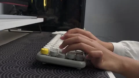 Side view of hands working with wireless keyboard on computer desk Stock Footage 276586654