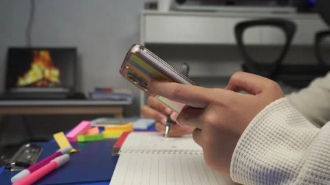Side view hands writing on book and holding phone on desk Stock Footage 276877183