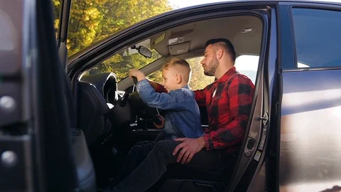 Side view of handsome bearded man which sitting with his nice son on the front Stock Footage 121661272