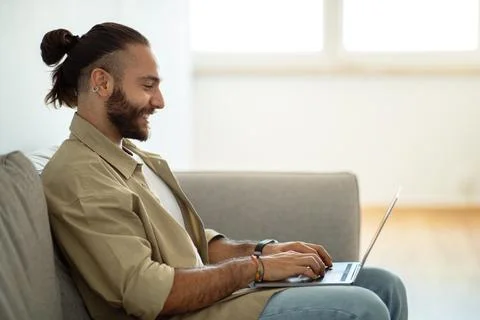 Side view of handsome guy typing on laptop keyboard Foto stock