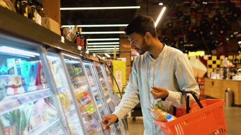 Side view of handsome indian man buying cheese. A man shopping cheese in grocery Stock Footage 251824761