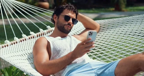 Side view of a handsome man with tanned skin on vacation, playing virtual online Stock Footage 220772607