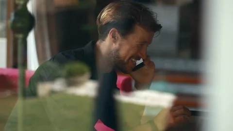 Side view of handsome young man talking on the mobile phone and smiling while Stock-Footage 85523660