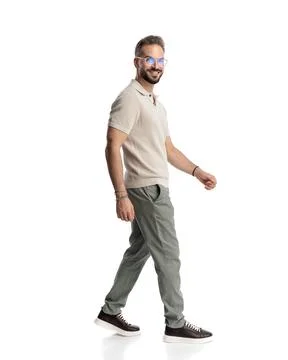 Side view of happy casual guy with glasses smiling and stepping forward Stock Photos