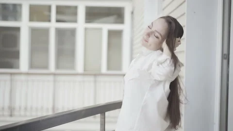 Side view of happy relaxed young woman enjoying weekend morning on balcony Video stock 144613376