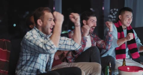 Side view of happy successful multi-ethnic friends celebrating football victory Video stock 148161615
