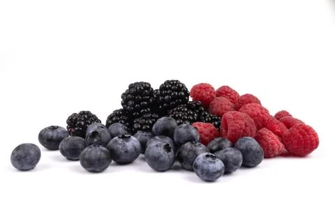 Side view on a heap of three types of berries laying on white background Stock Photos