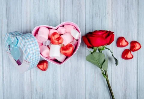 Side view of a heart shaped gift box filled with pink marshmallow and chocola Stock-Fotos