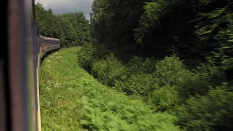 Side view of high-speed turning train on landscape of beautiful nature wild Stock Footage 157656045