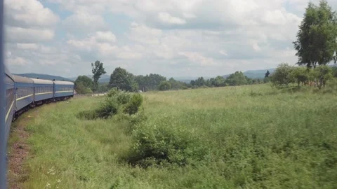 Side view of high-speed turning train on landscape of beautiful nature wild Stock Footage 157737228