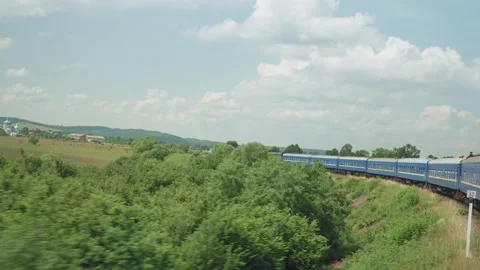 Side view of high-speed turning train on landscape of beautiful nature wild Stock Footage 157889286