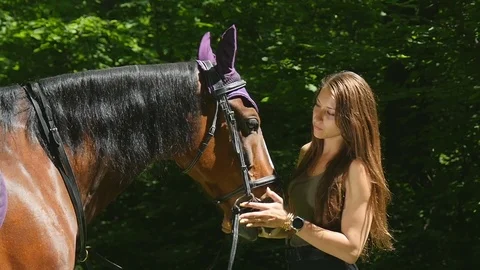Side view horsewoman with long hair in the forest with her horse Stock Footage