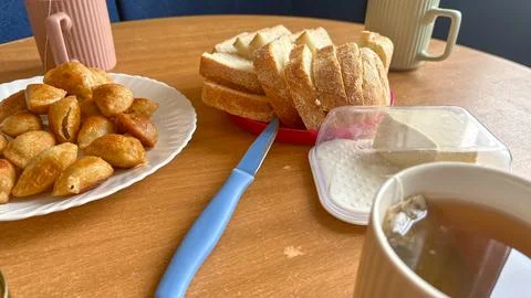 Side view of hot aromatic tea, fried dumplings on plate and sliced bread on Stock Photos