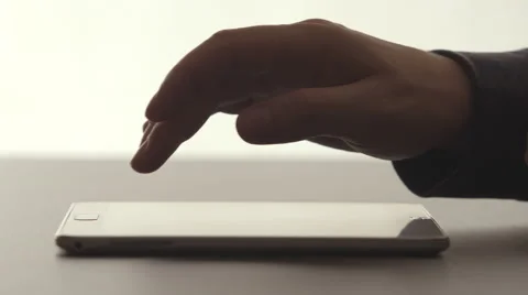 SIDE VIEW: A human hands touching by a finger on a tablet PC on a desk Видео 66786660