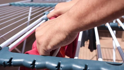 Side view of a husband hanging the laundry outdoors on a sunny day Stock Footage 166210407