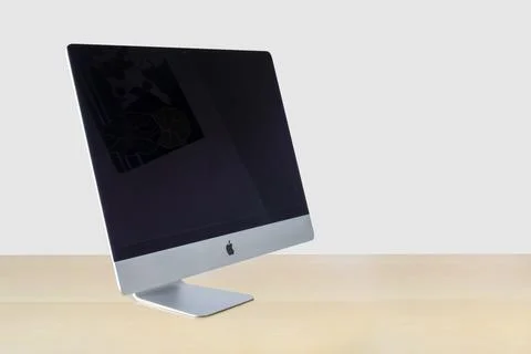 Side view of an iMac computer on a wooden table with a white background Stock Photos