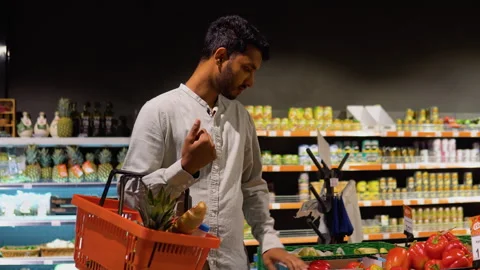 Side view of indian man buying tomato in supermarket Video stock 251825260