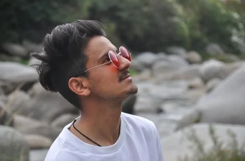 Side view of a Indian young guy with wearing white t-shirt and red sunglasses  Stock Photos