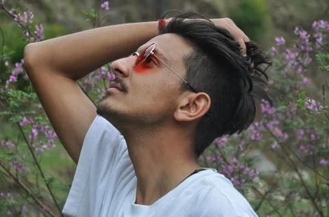 Side view of a Indian young guy wearing white t-shirt and red color sunglass Foto stock