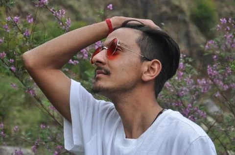 Side view of a Indian young guy wearing white t-shirt and red color sunglass  写真素材