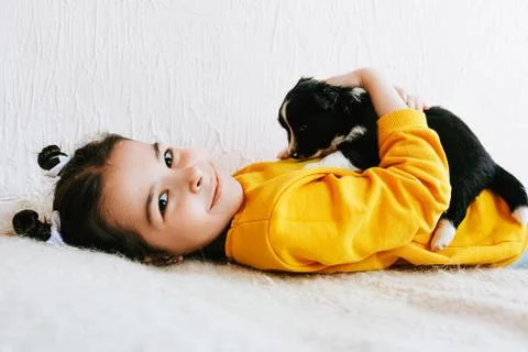 Side view indoor image of a smiling happy child playing at home with a little Stock Photos