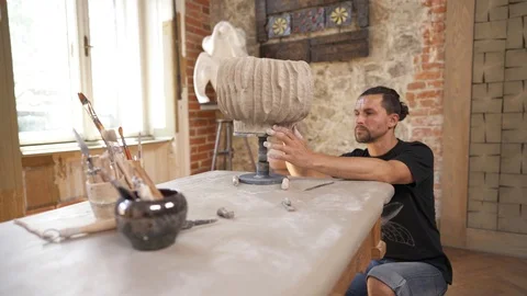 A side view of an inspired potter shaping ceramics pot. Clay product made with Stock-Footage 113080321