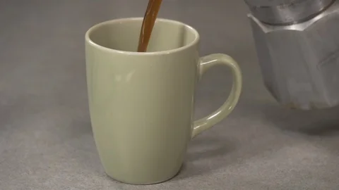 Side view- italian coffee maker pouring coffee in a green cup 4k. Stock Footage 96142042