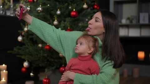 Side view joyful young mother and cute little daughter grimacing taking selfie Stock Footage 219913259