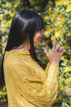 Side view of Kali mudra executed by a woman over nature background Stock Photos