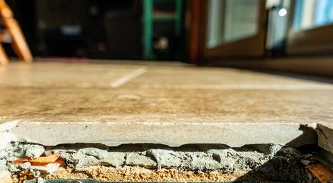 Side view of a kitchen flooring cutout with tile, grout, and plywood Stock Photos