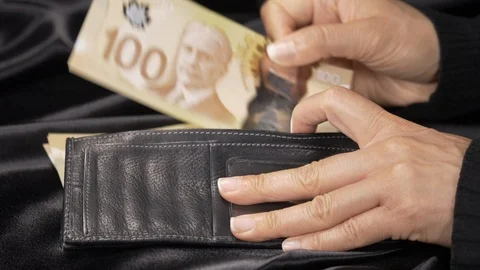 Side view - a lady inserting hundred dollar bills into a wallet. 4k Stock Footage 96010810