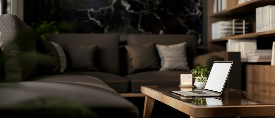 A side view of a laptop on a coffee table in a modern black living room. Stock Illustration