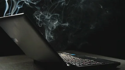 SIDE VIEW: Laptop is emitting smoke - Slow Motion Stock Footage 101044069