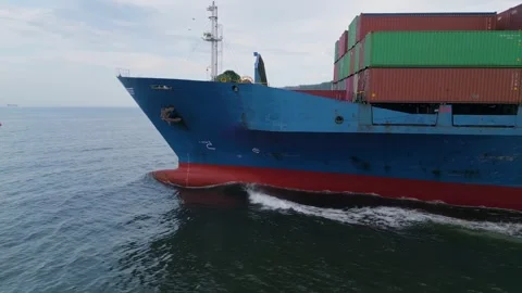 Side view of a large blue cargo ship loaded with shipping containers sailing Stock Footage 310313552