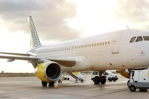 Side view of large white passenger airplane parked at terminal airport on r.. Stock Photos