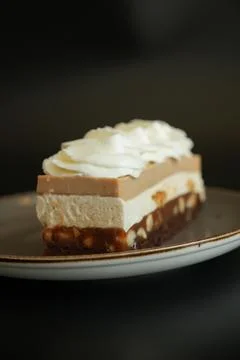 Side View of Layered Snickers Cake with Whipped Cream Topping Stock Photos