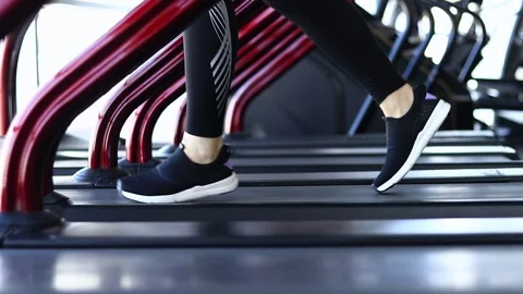 Side view of legs in sneakers running on the treadmill in the fitness room Stock Footage 283388283