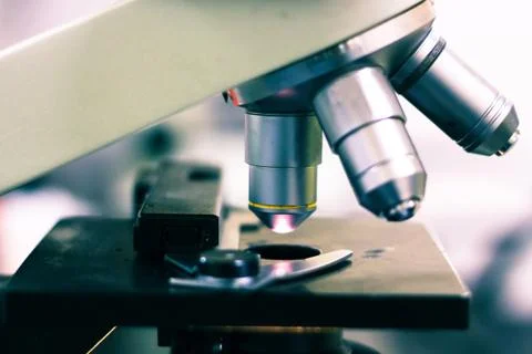 Side view of a light microscope showing the light on and optical eye piece ma Stock Photos